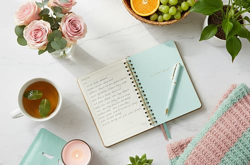 Sunday reset routine flatlay with journal, tea, candle, fresh flowers and planner on marble surface