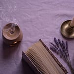 Peaceful slow living flatlay with lavender candle herbal tea and open book on linen